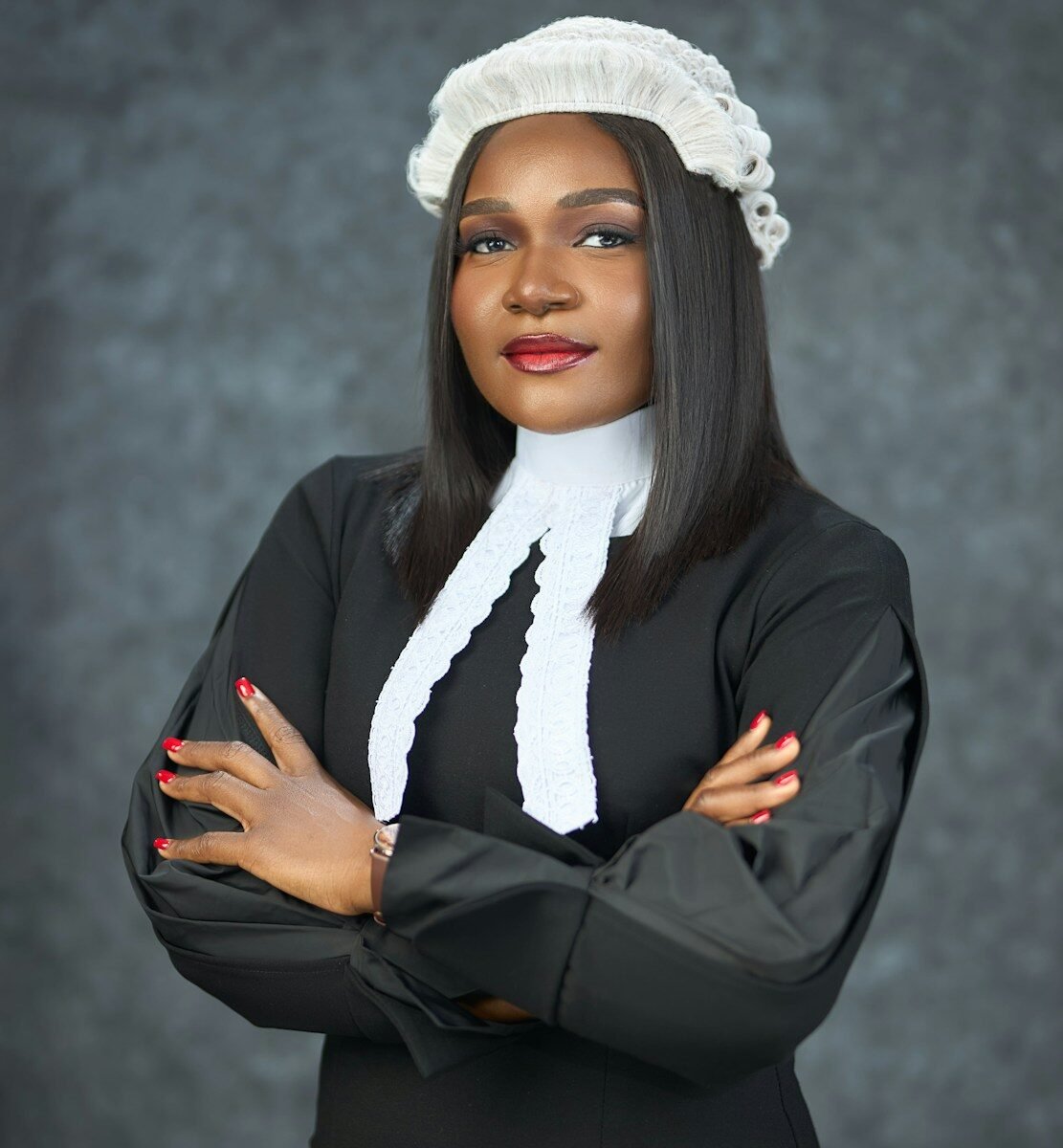 A woman in legal attire with arms crossed