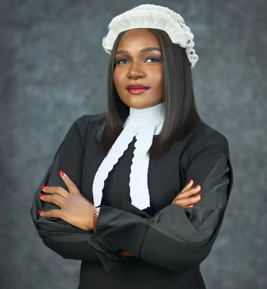 A woman in legal attire with arms crossed