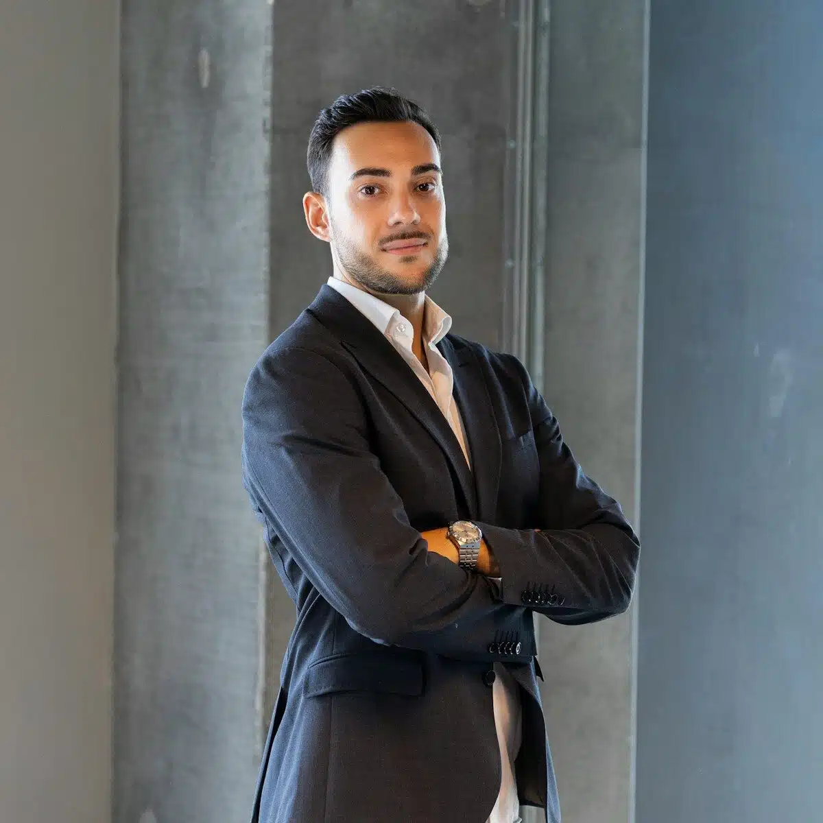 a man in a suit standing with his arms crossed