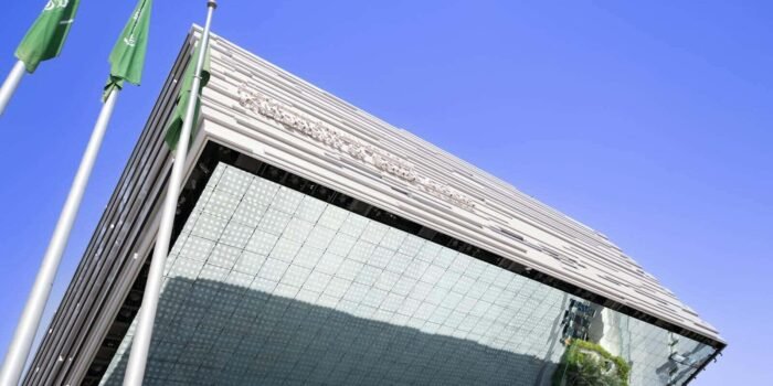 Low angle view of a modern building with flags in Dubai, UAE.