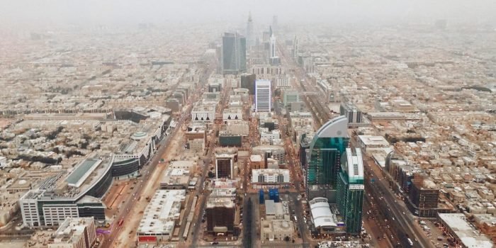 Aerial photograph of Riyadh's modern cityscape with iconic skyscrapers and bustling streets.