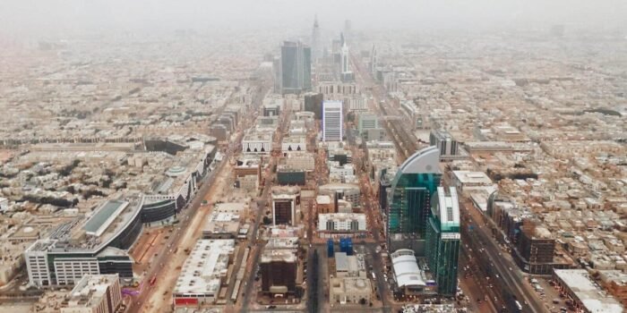 Aerial photograph of Riyadh's modern cityscape with iconic skyscrapers and bustling streets.